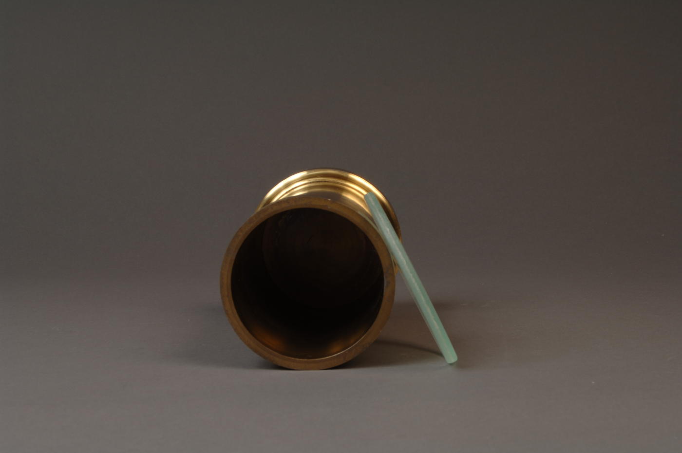 Brass volumetric standard, top view with glass cover laying at side