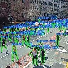 This image shows people running on a road with a technology overlay showing video object detection.