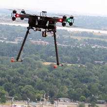 Quadcopter flying in the air over trees