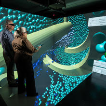 Researchers wearing virtual reality headsets in the CAVE, with concrete particles on display