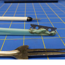 Shivs and other homemade weapons laying on a blue surface