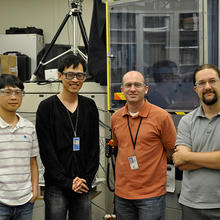 Four men stand looking at the camera