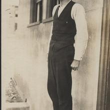 man in a suit standing by a building