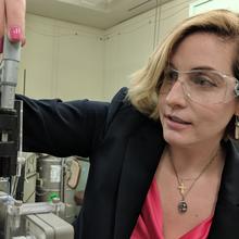 Mary Kombolias load a small blue piece of paper into a dielectric spectrometer.