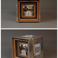 Tow large metal boxes with a wood box in between, then space, then two more metal boxes with wood box inbetween and inside of that is the inside of a quartz time standard