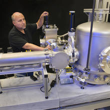 Man standing behind big silver equipment