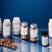 Seven small bottles with labels including "River Sediment" and "Human Liver"