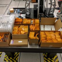 Boxes filled with yellow envelopes on a table.