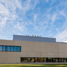 A large tan building with blue sky in the background.