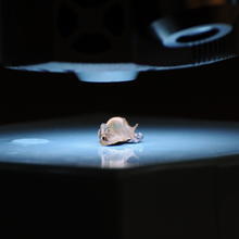 Bullet fragment is illuminated under microscope lens.