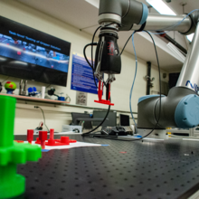 Robot arm picks up a red widget off a table
