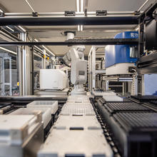 A robotic arm within the NIST Living Measurement Systems Foundry moves testing wells from one part of the system to another.