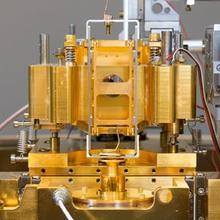 A copper-colored metal device stands on cylindrical legs.