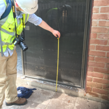 Travis Thonstad of the NIST Materials and Structural Systems Division measuring a high-water mark on a Houston, Texas residence after Hurricane Harvey in 2017.