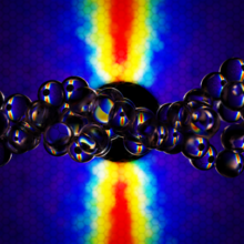 Colorful computer data patterns form a backdrop to a horizontal string of transparent spheres.