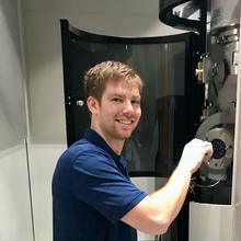 Jake Benzing places a sample in a microscope