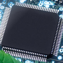 banner image of a semiconductor chip buried under green leaves in nature