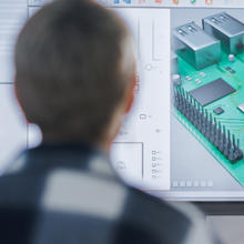 Man standing in from of presentation screen displaying microcontroller