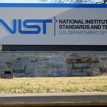 Outdoor sign in close-up view reads: NIST: National Institute of Standards and Technology: Gate A