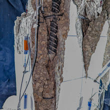 Close-up view of vertical fissures and exposed rebar in test column with sensors and markers still attached. 
