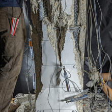 A vertical column with sensors attached has shredded-looking cracks and broken parts. 