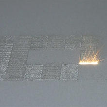 A high-power laser spot scans back and forth over a layer of cobalt-chrome powder on NIST's powder bed fusion additive manufacturing machine. Where it touches, the powder melts and fuses to underlying layers until a fully dense 3D metal part is formed. The laser travels back and forth so fast that, in this still image frame, it appears to form a white hot stripe about 10 millimeters wide.
