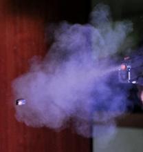 Bullet being expelled from gun with resulting smoke and residue