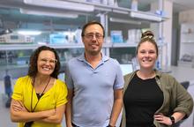 three people standing in a laboratory