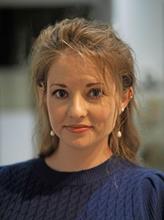 Portrait of Dr. Jessica Frick, a woman with long brown hair, wearing a blue sweater
