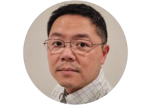 person with short black hair and glasses