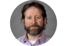 person with brown hair and a beard