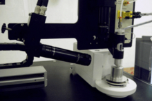 a drop-on-demand dispenser fed by a reservoir of standard solution