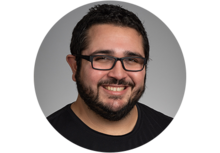 NIST's Nick Derimow, a person with dark brown hair, a beard and glasses, smiles for the camera.