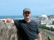 Dave McColskey stands overlooking a coastal city.