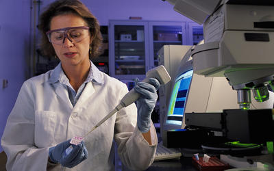 NIST biomedical engineer Laurie Locascio places a water sample on a highly sensitive, inexpensive "lab-on-a-chip"