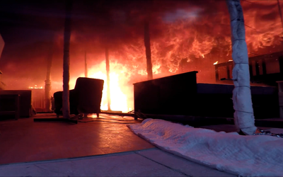 Flames roll on the ceiling of a darkened burning test room one minute before a flashover occurs.