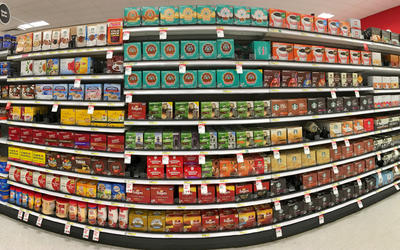 Fisheye view of grocery store shelves packed with coffee products.