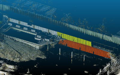 Lidar image of building collapse site looks like a black-and-white photo with some parts of the remaining walls marked in yellow and red.
