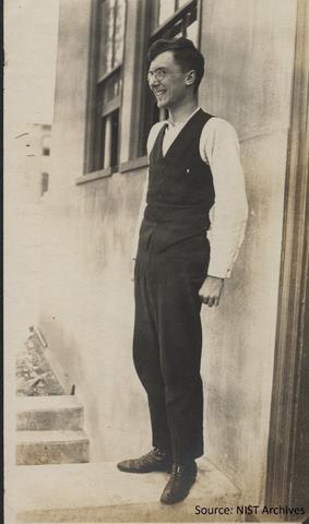man in a suit standing by a building