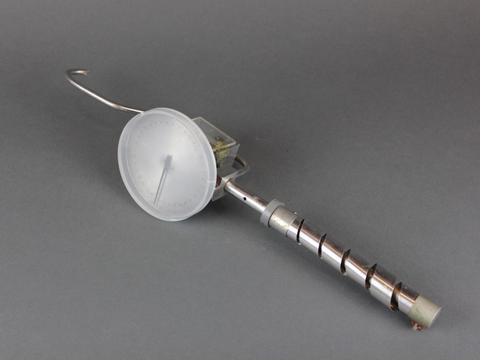Scientific device has dial and hook on one end, spiral handle on the other.