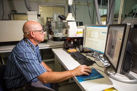 Photo of a NIST scientist working in front of a monitor.