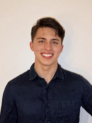 George Sellers poses for a casual head shot against a white wall. 