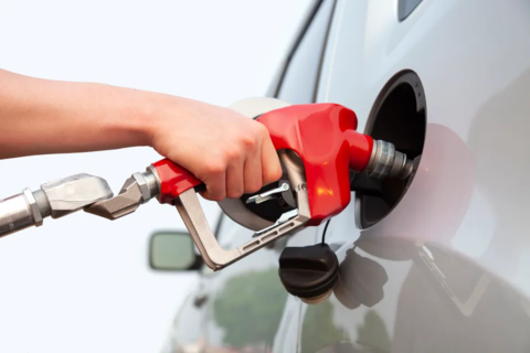 Photo of Hand holding a gas pump handle pumping gas into a vehicle