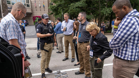 Attendees observing public safety demo from local police department outside the hotel at 5x5