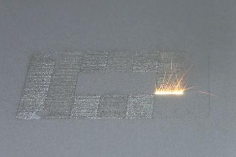 A high-power laser spot scans back and forth over a layer of cobalt-chrome powder on NIST's powder bed fusion additive manufacturing machine. Where it touches, the powder melts and fuses to underlying layers until a fully dense 3D metal part is formed. The laser travels back and forth so fast that, in this still image frame, it appears to form a white hot stripe about 10 millimeters wide.