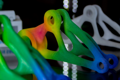 an abstract rainbow colored shape 3D printed by fusing powdered material together