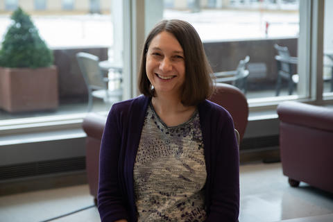 Julie Haney poses smiling for a casual portrait in the NIST library. 
