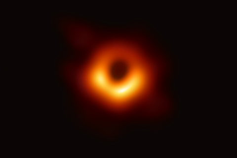 Black hole appears as glowing orange doughnut on a black background.