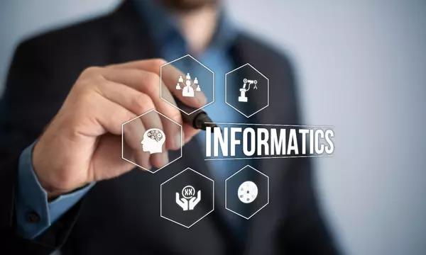 Technology related symbols with the word informatics, superimposed on a background with a man holding a pen.