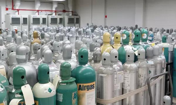 Photograph of hundreds of gas cylinders in a gas storage facility.